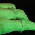 Hand photo wearing two glow-in-the-dark Slay the Spire Snake Rings that emit vivid green glow in darkness worn as cosplay accessories