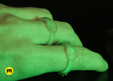Hand photo wearing two glow-in-the-dark Slay the Spire Snake Rings that emit vivid green glow in darkness worn as cosplay accessories