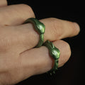 Hand photo of person wearing two 3D printed Slay the Spire metallic green Snake Rings on index and middle fingers showing wearable ring size