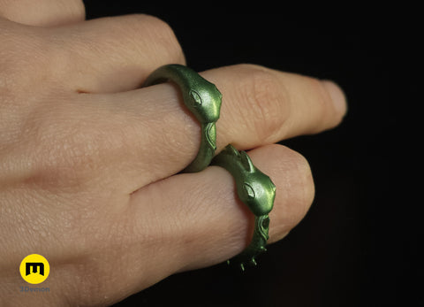 Hand photo of person wearing two 3D printed Slay the Spire metallic green Snake Rings on index and middle fingers showing wearable ring size