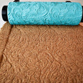 Photo of single turquoise 3D printed mandala roller next to its perfect imprint in brown sand showing crisp centered large mandala circle pattern