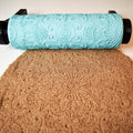 Photo of turquoise 3D printed starburst sunburst mandala pattern roller lying next to its clear geometric concentric star shape imprint in brown clay