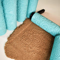 Close-up product photo of multiple turquoise 3D printed mandala texture rollers standing vertically showing fine geometric and floral embossed surface patterns