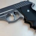Lifestyle photo of 3D printed Grace Ashcroft Handgun RE Requiem low angle side profile black slide brown wood-grip on dark textured surface