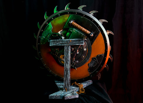 Lifestyle photo of 3D printed Shield Saw Stand with Doom weapon mounted front view showing green orange battle-worn shield