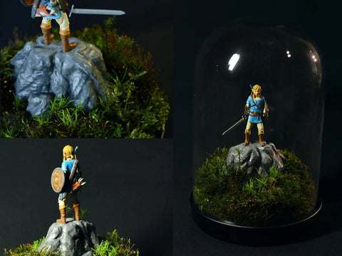 3D printed Legend of Zelda Link figures in a moss terrarium under an IKEA glass dome