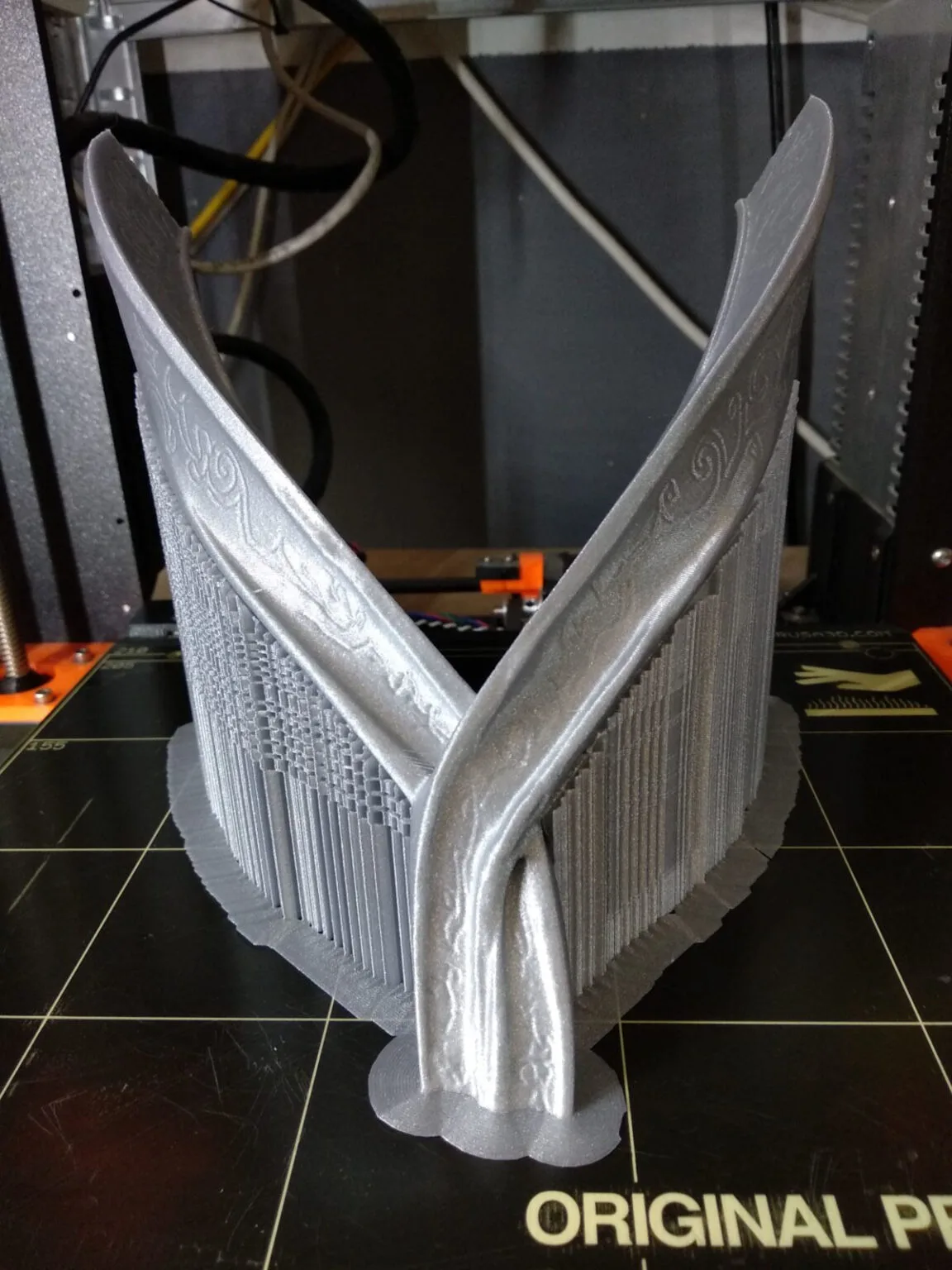 Real photo of a 3D printed Dark Mountain helmet from Game of Thrones, painted silver, held in hands.