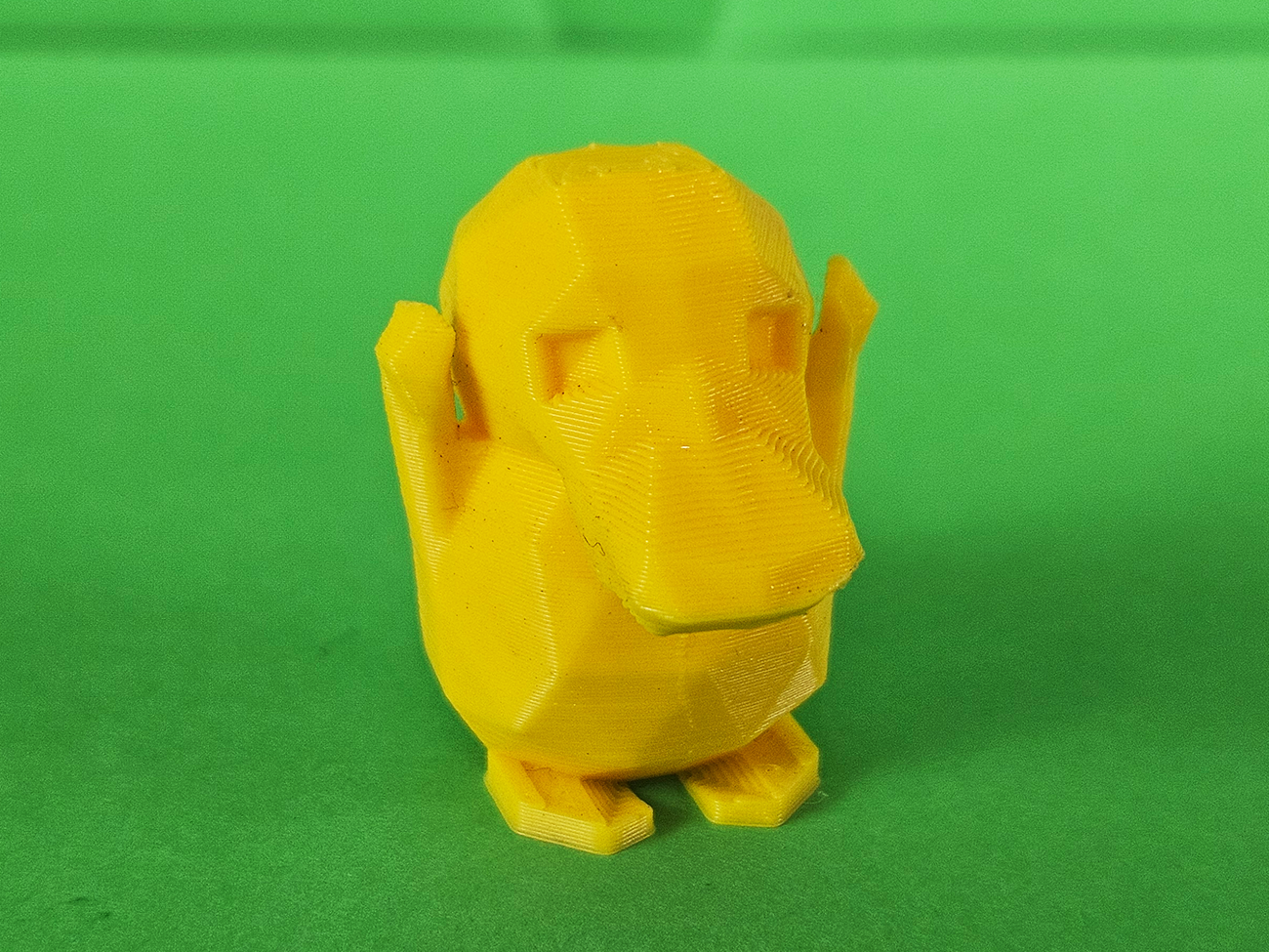 Photo of 3D printed Psyduck STL collectible figure, yellow, rear view, plain green background