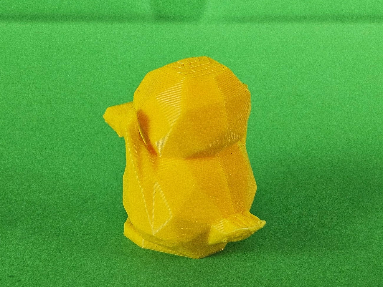 Side view photo of 3D printed Psyduck STL collectible figure, orange, plain green background