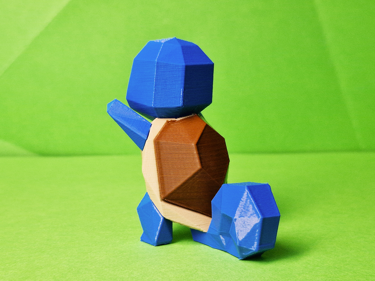 Photo of 3D printed Squirtle STL collectible figure, blue/brown shell, side view, plain green background