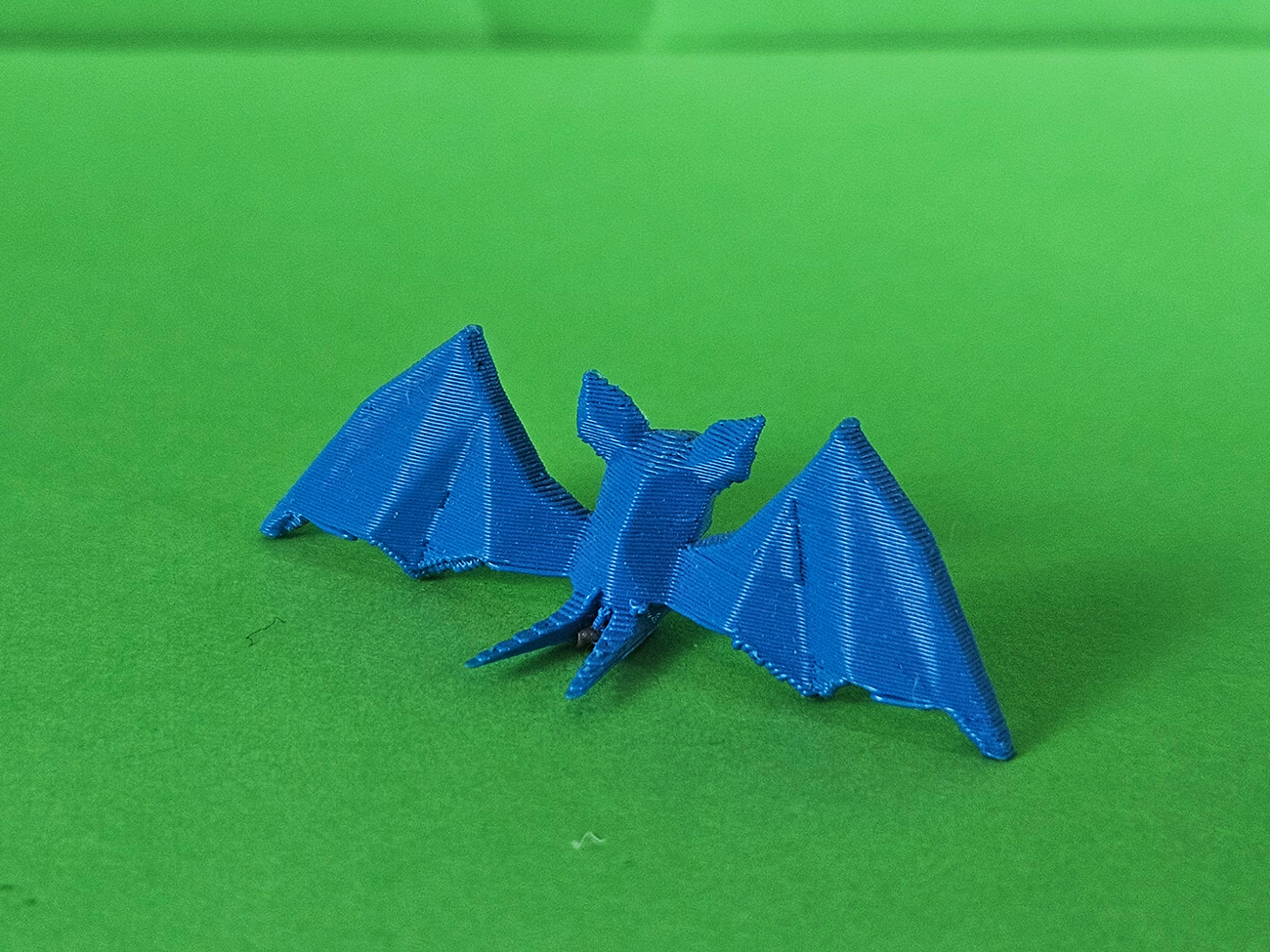 3D printed Zubat STL collectible figure, blue, side profile view on green background