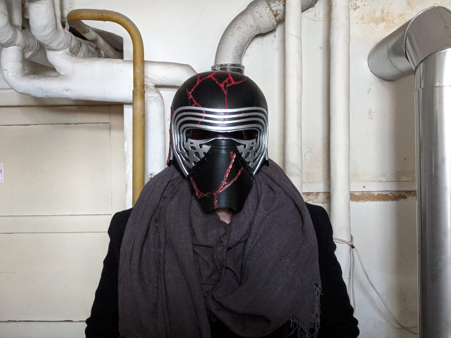 The Kylo Ren helmet destroyed - Star Wars, black 3D printed cosplay prop, damaged red-cracked detail.