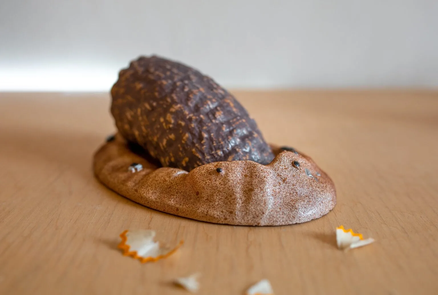 Lifestyle photo of Sandworm Pencil Sharpener - Dune, 3D printed on wooden surface with broken chalk pieces.