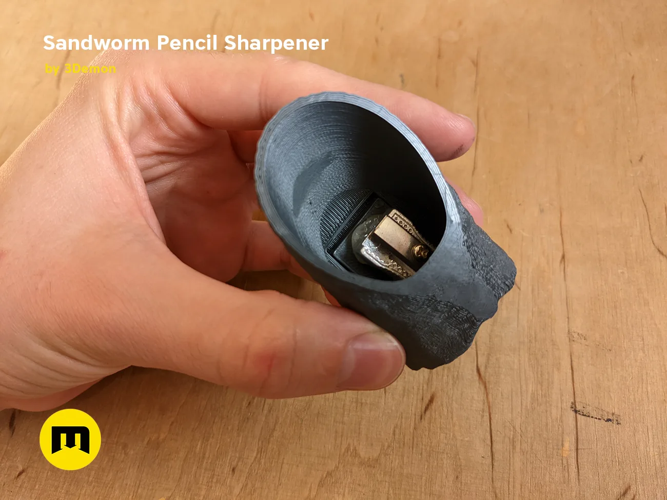 Hand photo of Sandworm Pencil Sharpener - Dune 3D printed model, black sand-textured design, held in hand