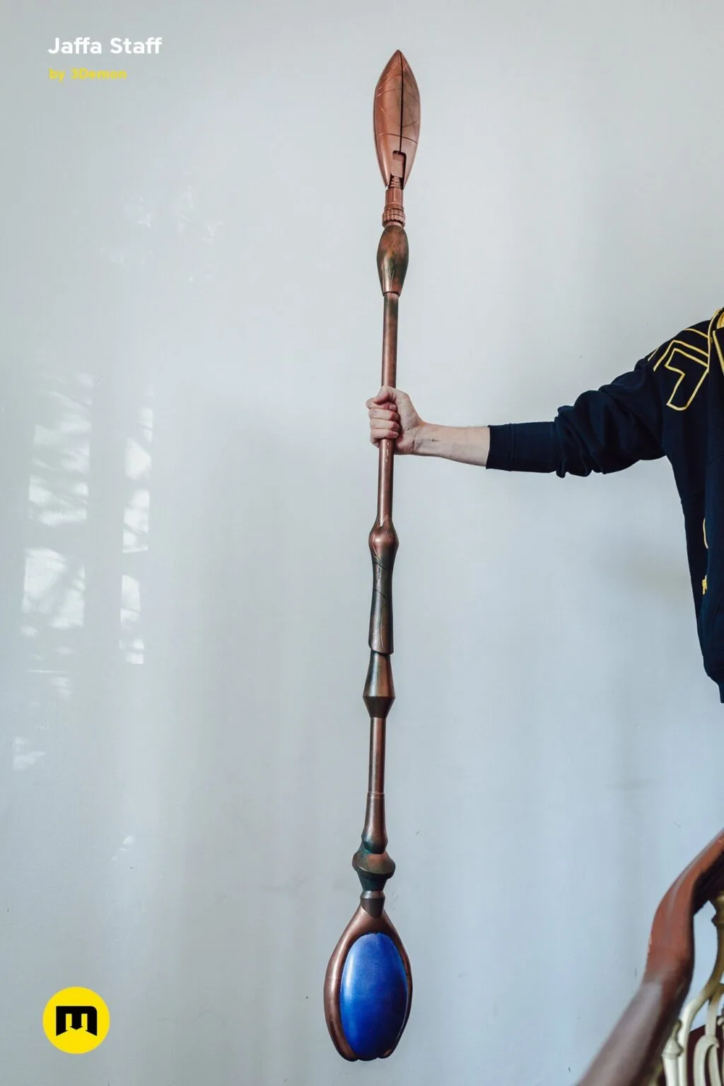Hand photo of Ma'Tok Jaffa Staff, bronze 3D printed cosplay prop with blue tip, held upright
