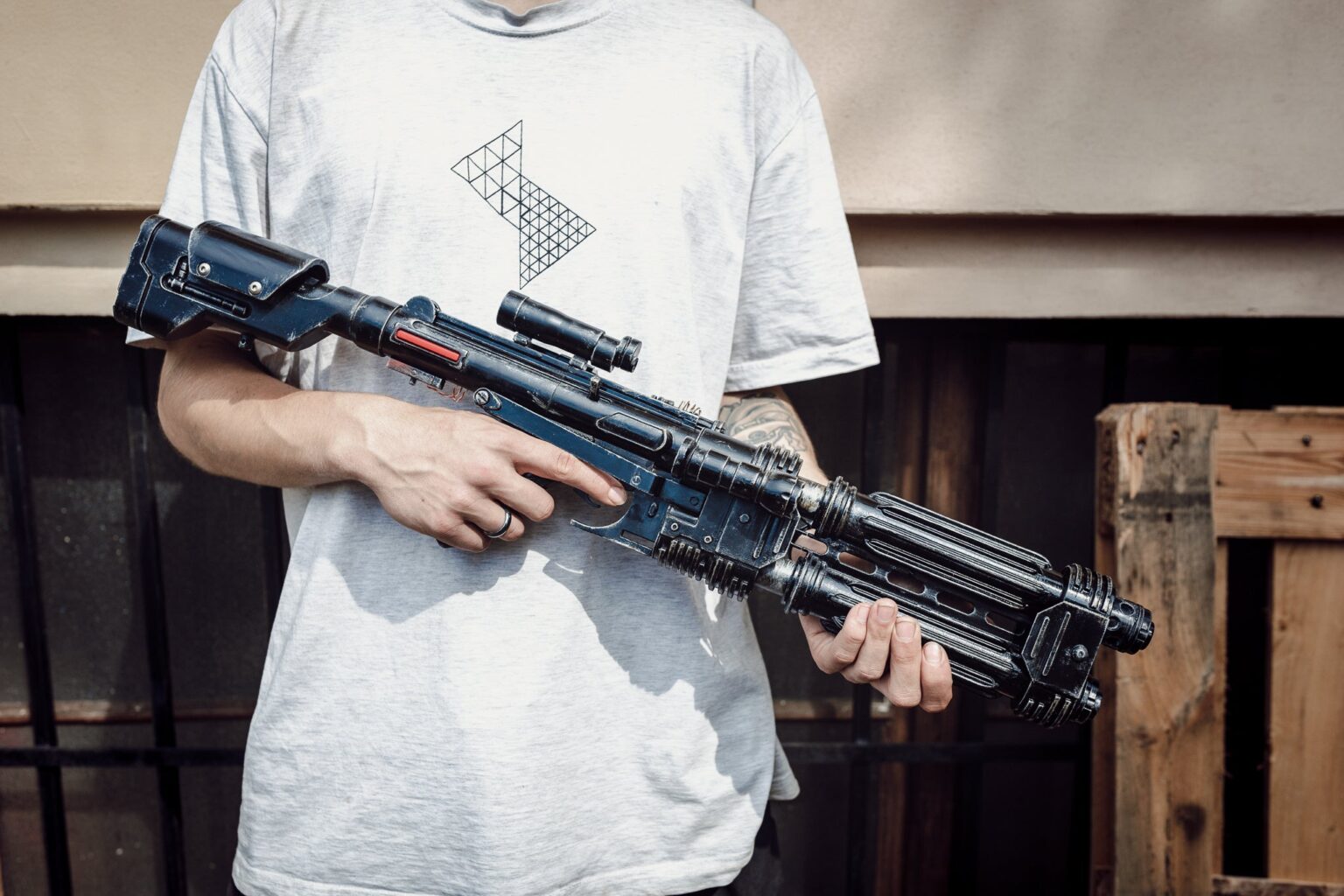 Hand photo of E-22 Blaster Pistol, black 3D printed weapon cosplay prop, detailed grip and scope.