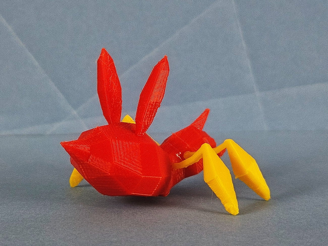 Color-coded parts breakdown of Ariados STL, red body with yellow limbs, 3D printed creature model