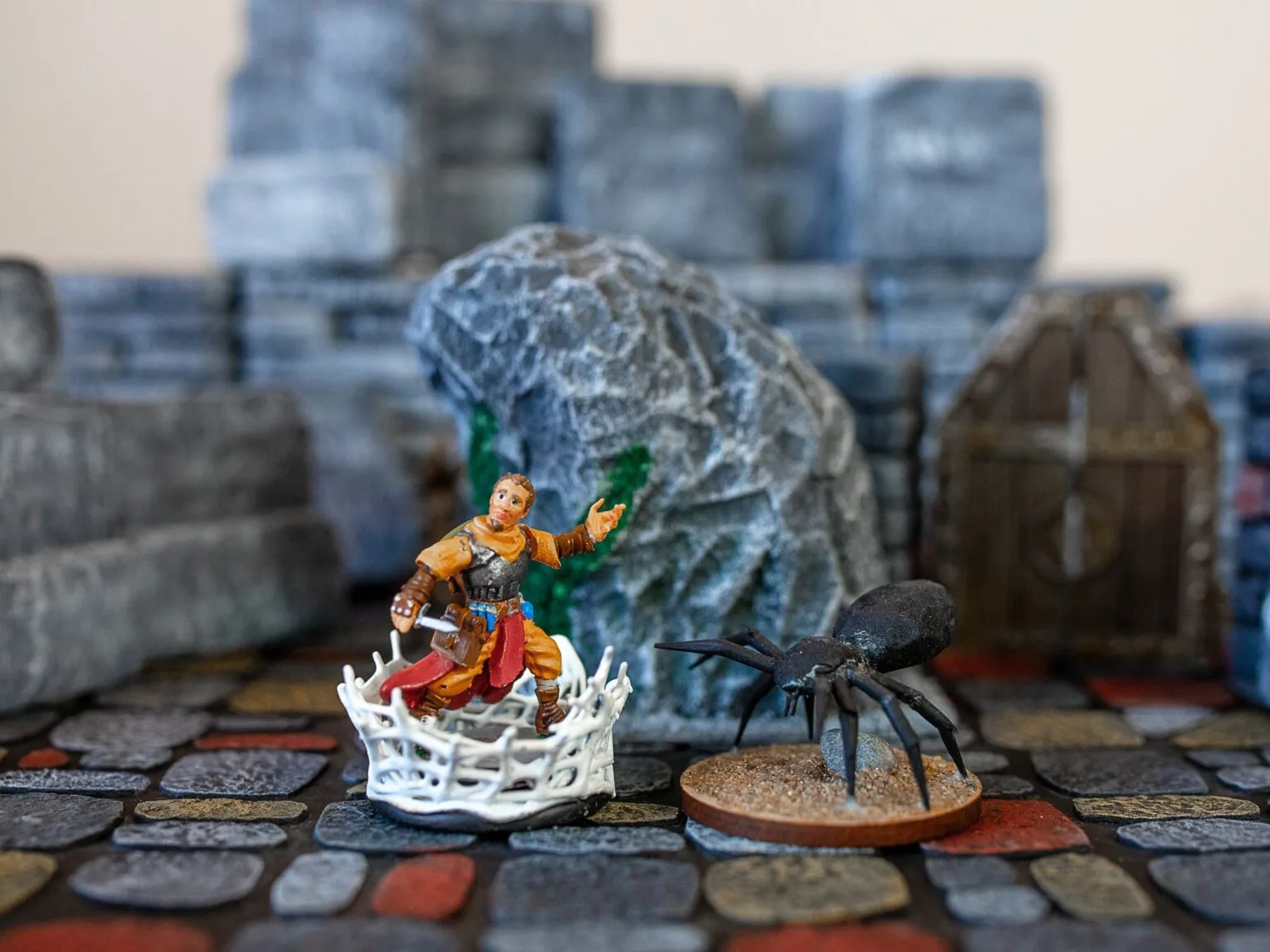 Lifestyle photo of 3D printed DnD Practical Condition Markers, spider and damaged knight figure on stone terrain.