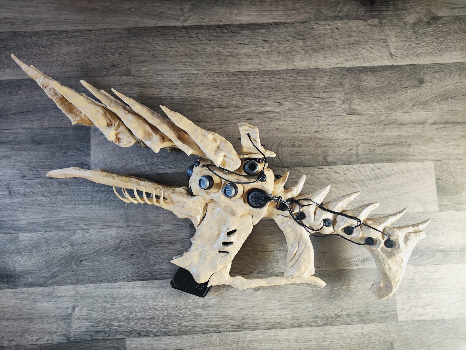 Lifestyle photo of 3D printed One Thousand Voices Fusion Rifle, three-pronged barrel with glowing eyes.