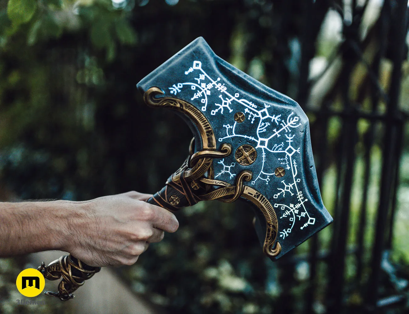 Hand photo of 3D printed Mjolnir - God of War Ragnarok, dark blue hammer with white Norse runes, brass accents.