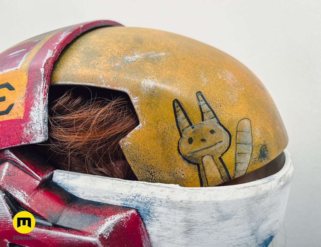 Close-up of Sabine Speeder Helmet - Ahsoka, 3D printed with Ahsoka Tano face detail, yellow and red.