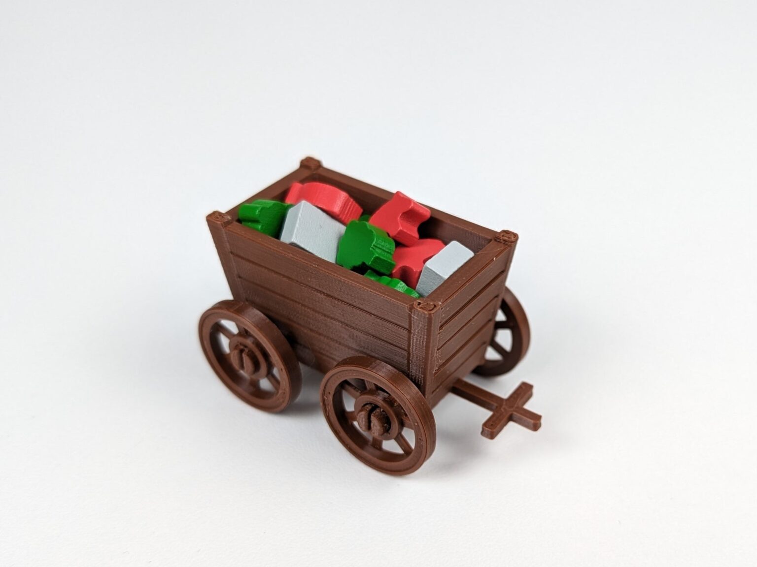 Lifestyle photo of a brown 3D printed resource cart filled with colorful board game tokens on a white background.
