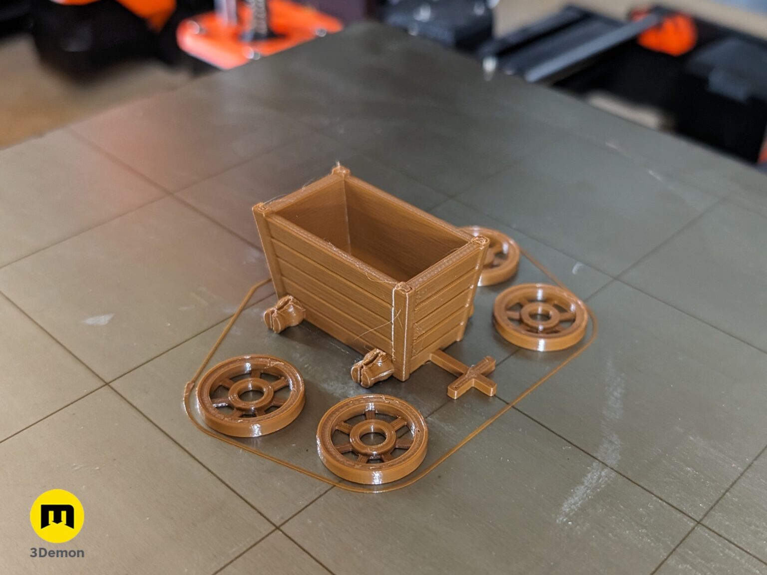 Lifestyle photo of 3D printed resource cart parts and wheels on a 3D printer build plate for Karak II board game.