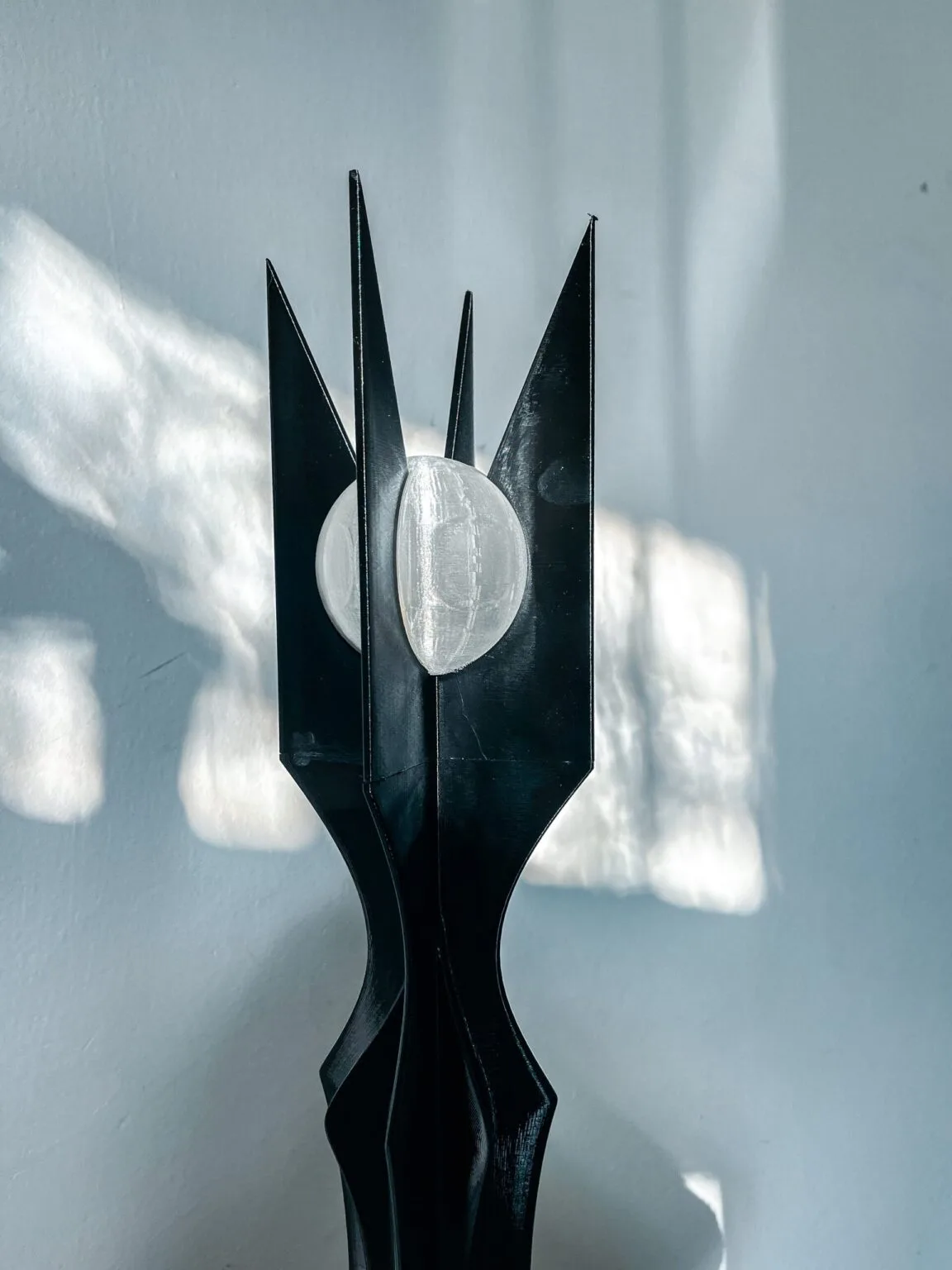 Lifestyle photo of a real 3D printed wizard staff held in hand against a forest background.
