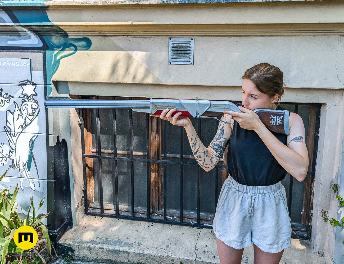 A person holding the finished Caitlyn rifle prop, showcasing the large 1:1 scale of the 3D printed model.