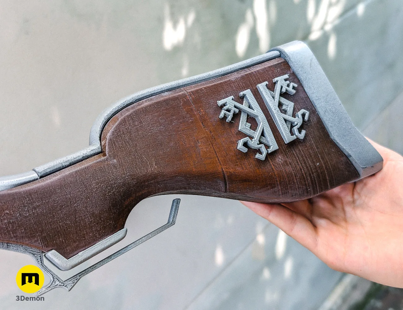Side-view photo of the assembled 3D printed Caitlyn rifle prop with a professional silver and wood-textured finish.