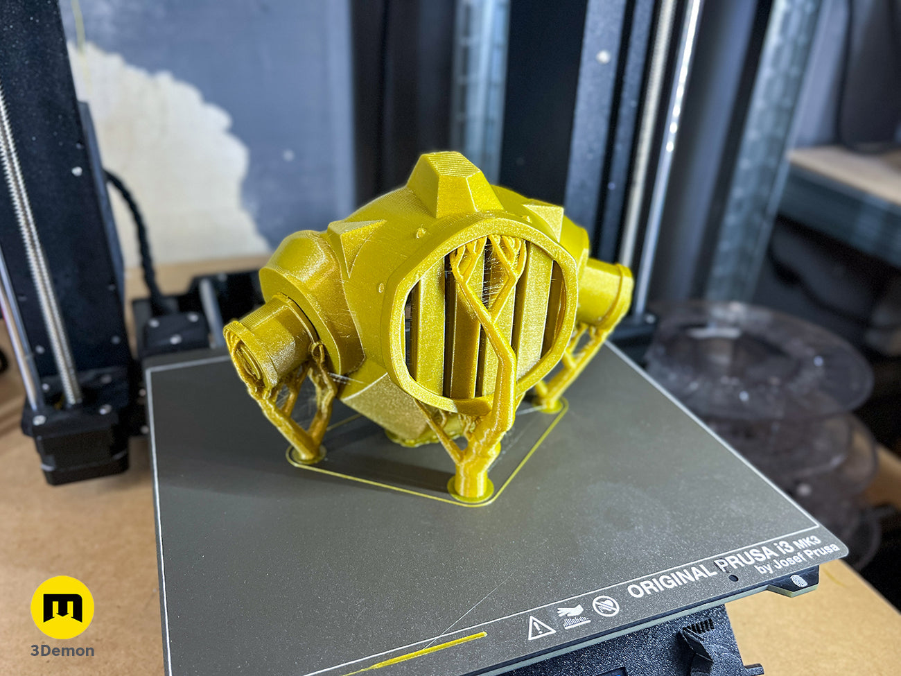 Side view of the 3D printed Jinx gas mask filter attachment, showing gold and dark grey painted details.