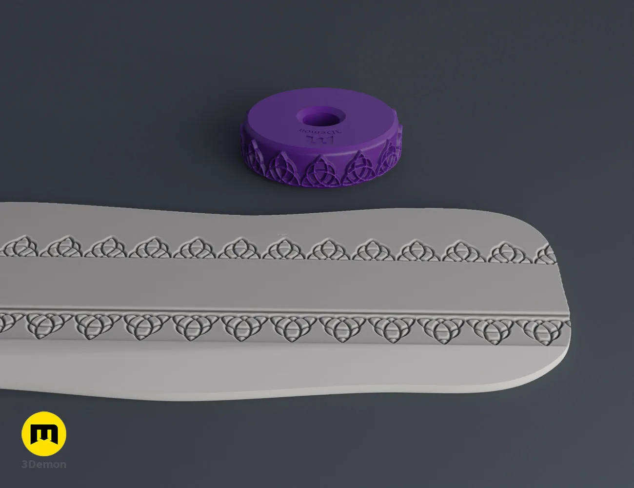 Purple 3D printed stamp wheel with a triskelion symbol and its impression on gray clay.