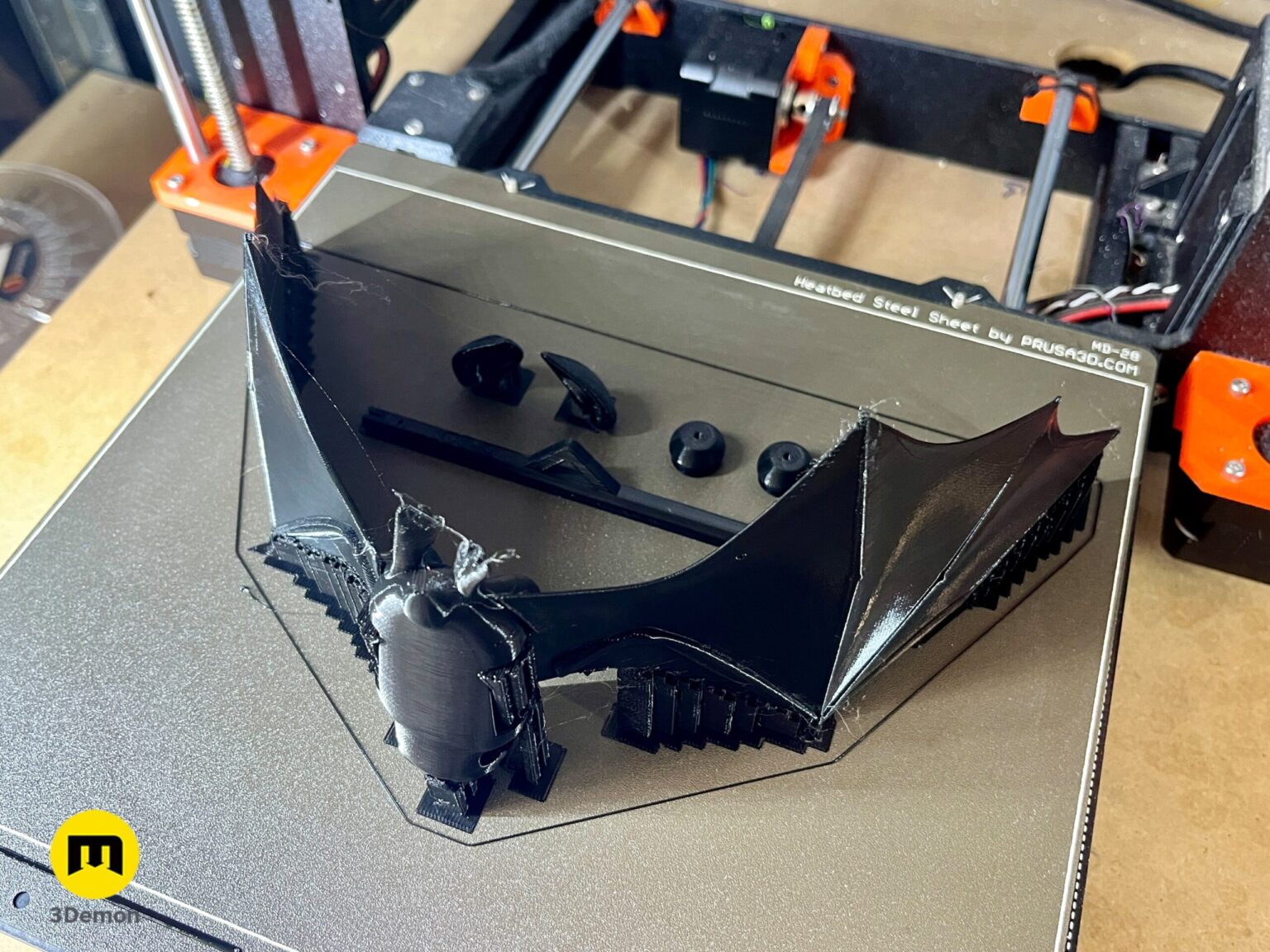3D printed black bat parts and strings on a table before assembly – Halloween Bat Flying Mobile 3D print | 3Demon