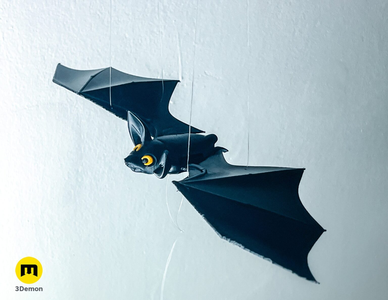Close-up of a 3D printed black bat with yellow eyes for a Halloween mobile – Halloween Bat Flying Mobile 3D print | 3Demon