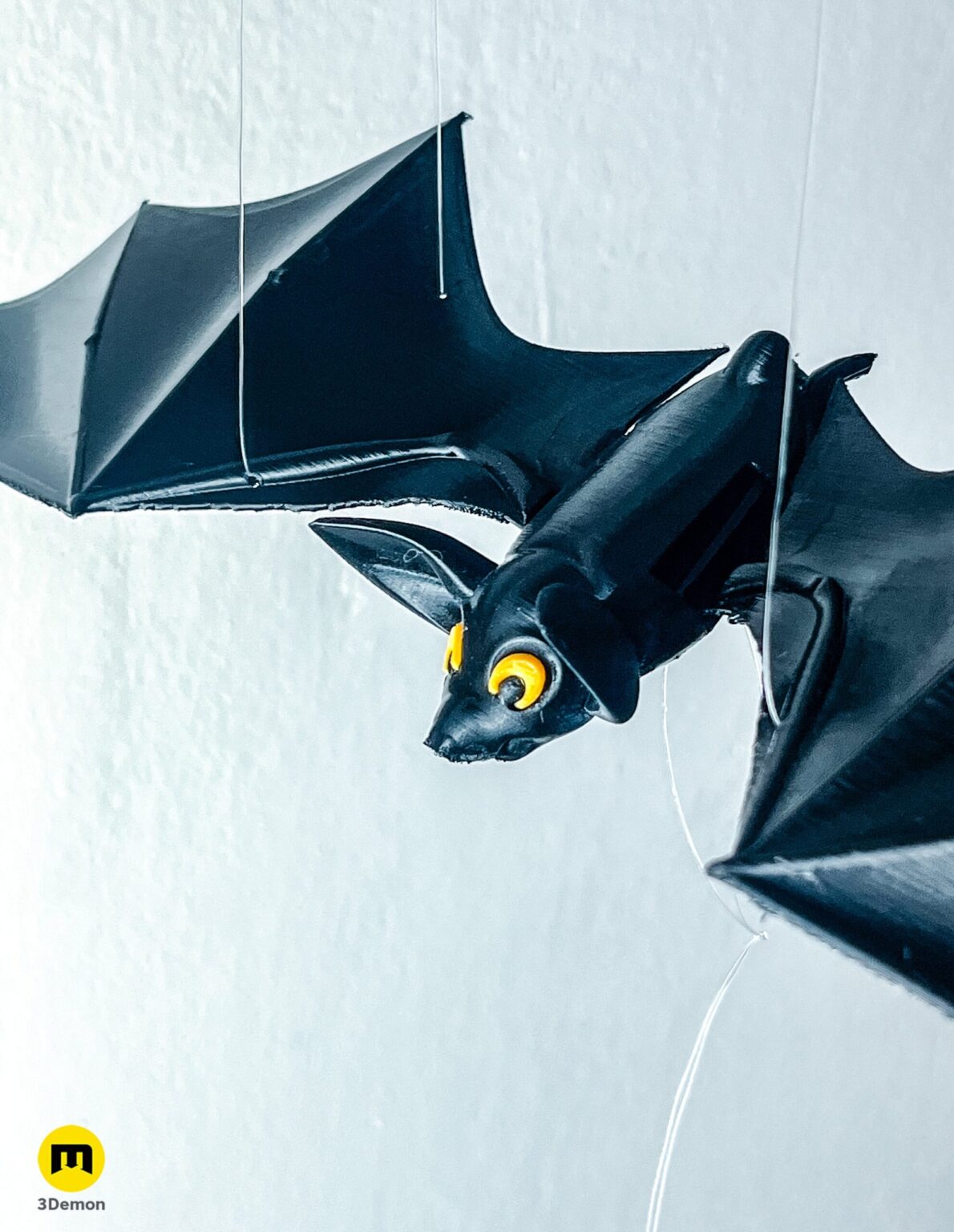 Perspective view of a black flapping bat mobile hanging against a white wall – Halloween Bat Flying Mobile 3D print | 3Demon