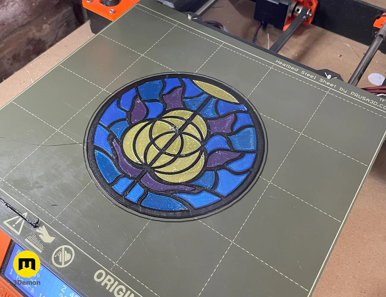 3D printed circular Elden Ring logo stained glass panel on a printer bed, featuring blue, purple, and yellow – Elden Ring Stained Glass 3D print | 3Demon