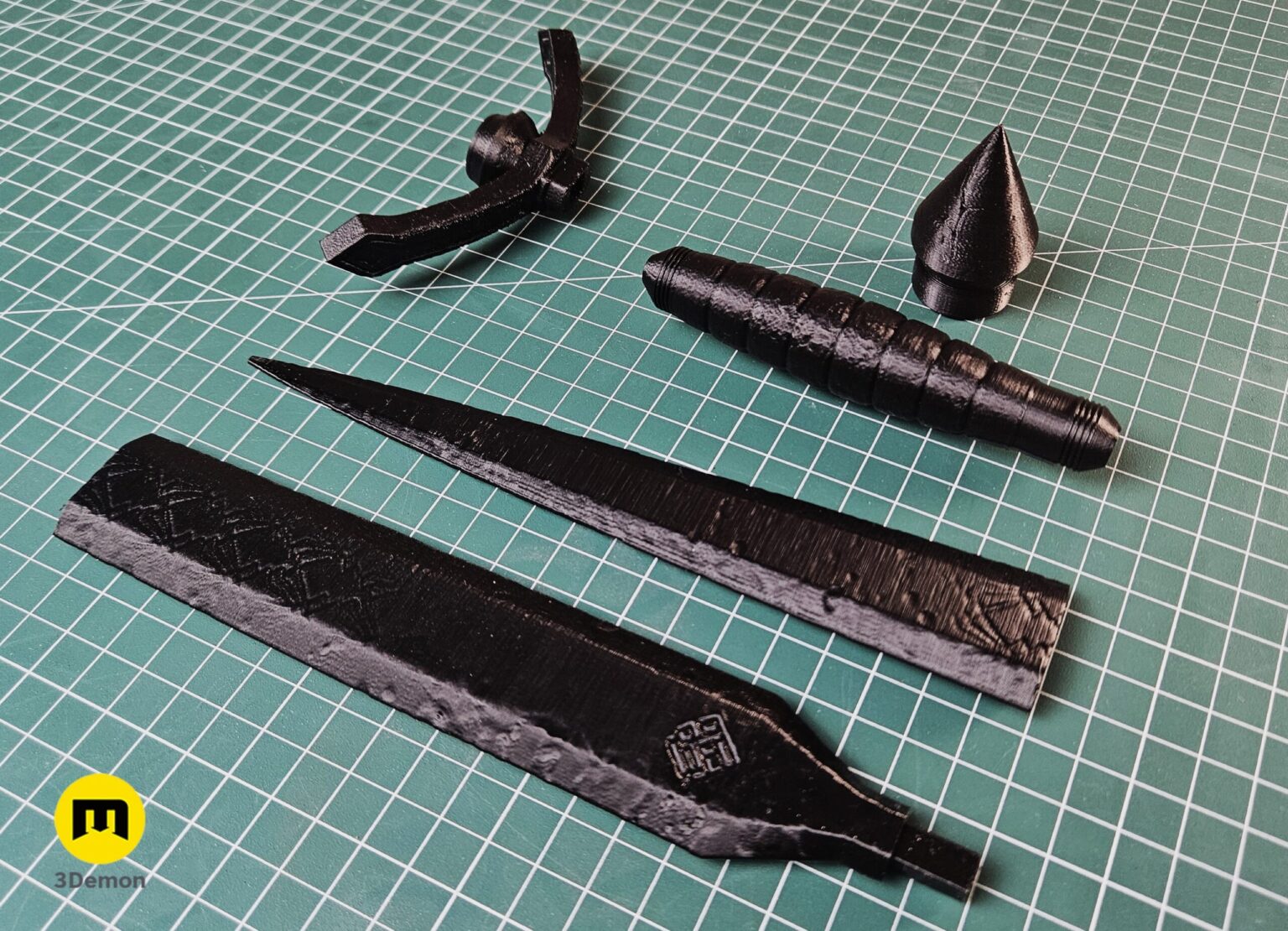 Photo of black 3D printed Expedition 33 Verso Dagger Verleso components laid out unassembled on green cutting mat showing individual pieces before gluing