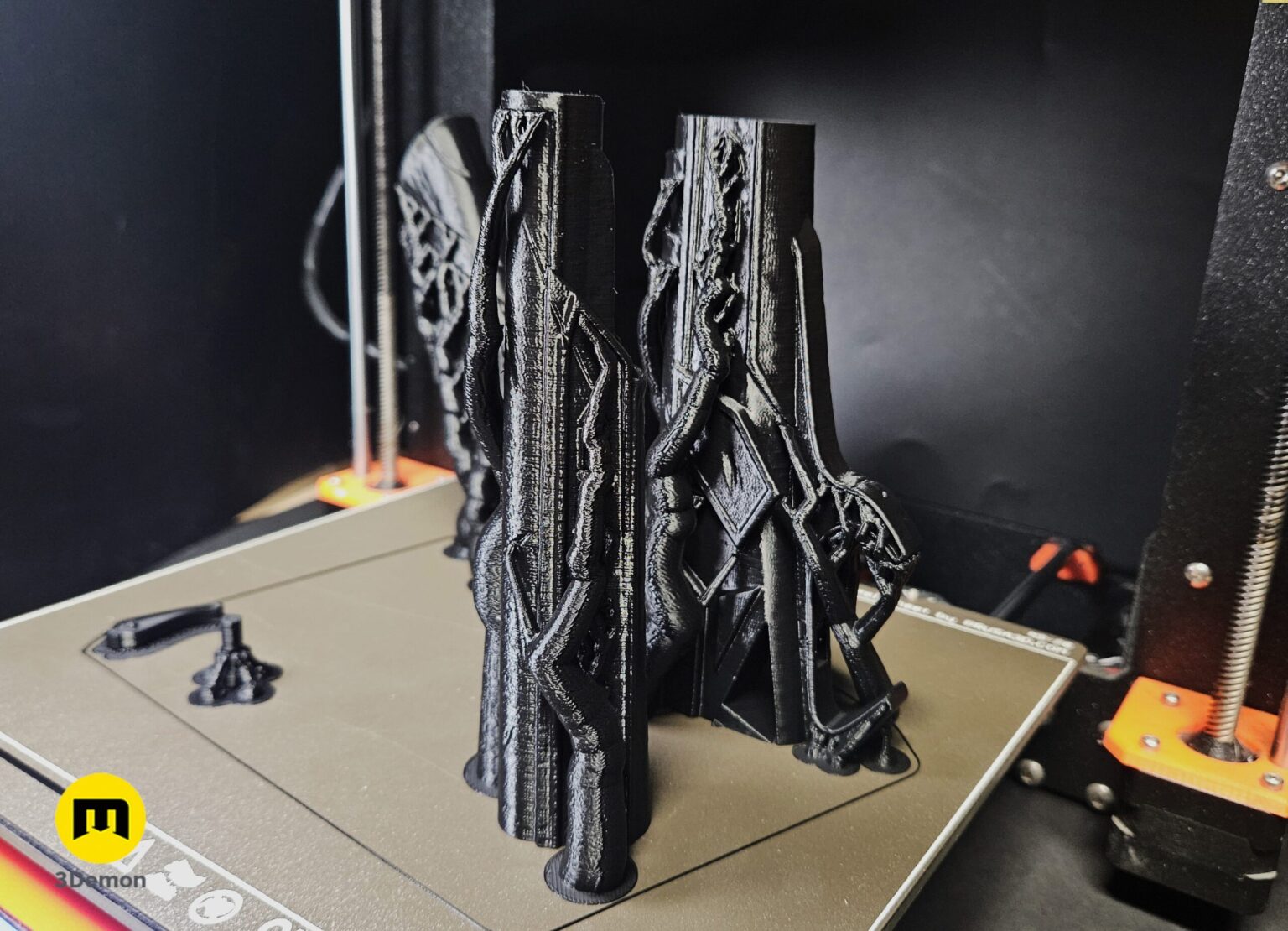 Photo of multiple grey 3D printed Expedition 33 Gustave Gun parts freshly removed from Prusa print bed showing raw plastic before post-processing and painting