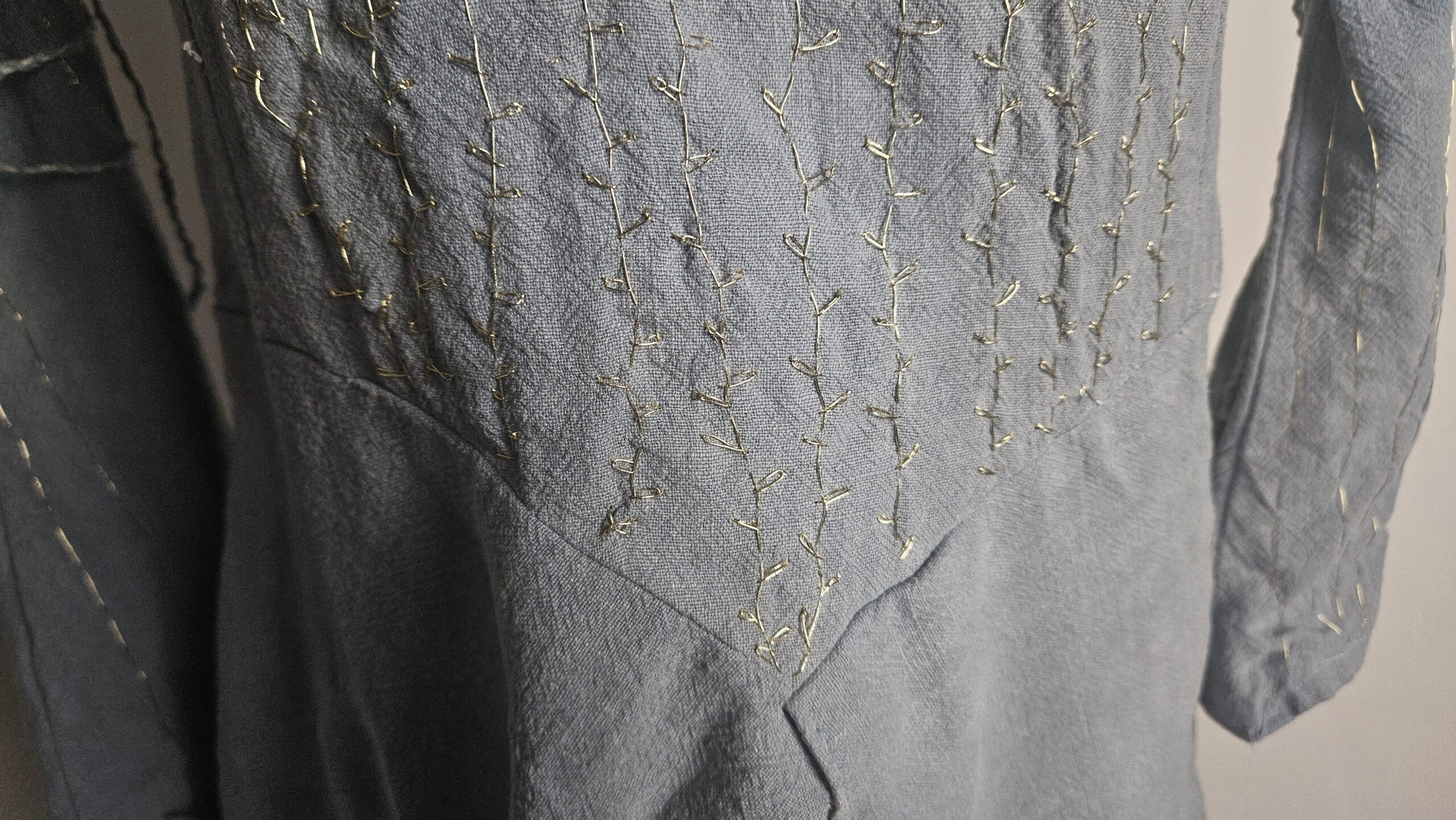 Side seam of the blue dress pinned during fitting