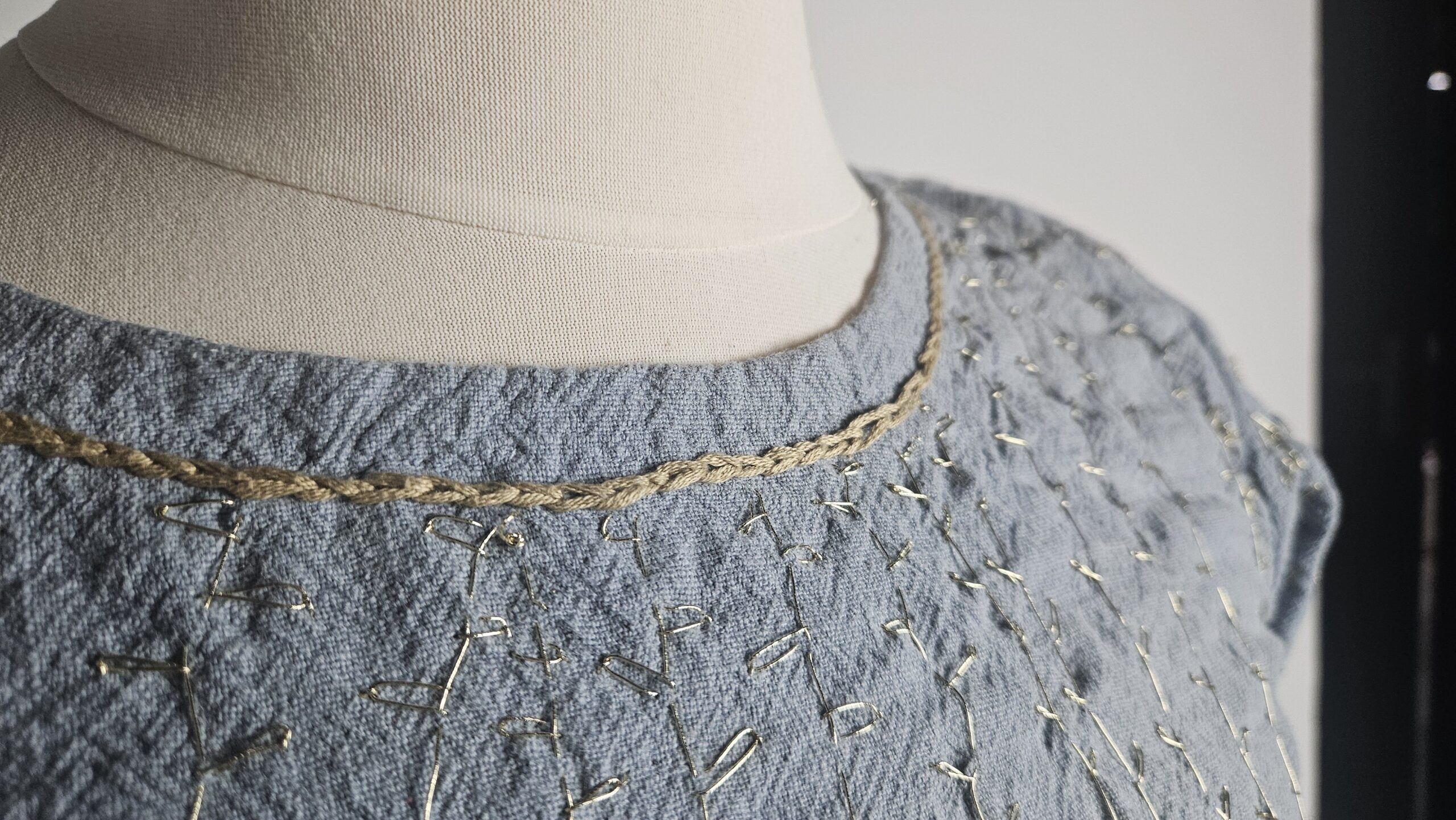 Gold embroidered neckline on the finished blue dress