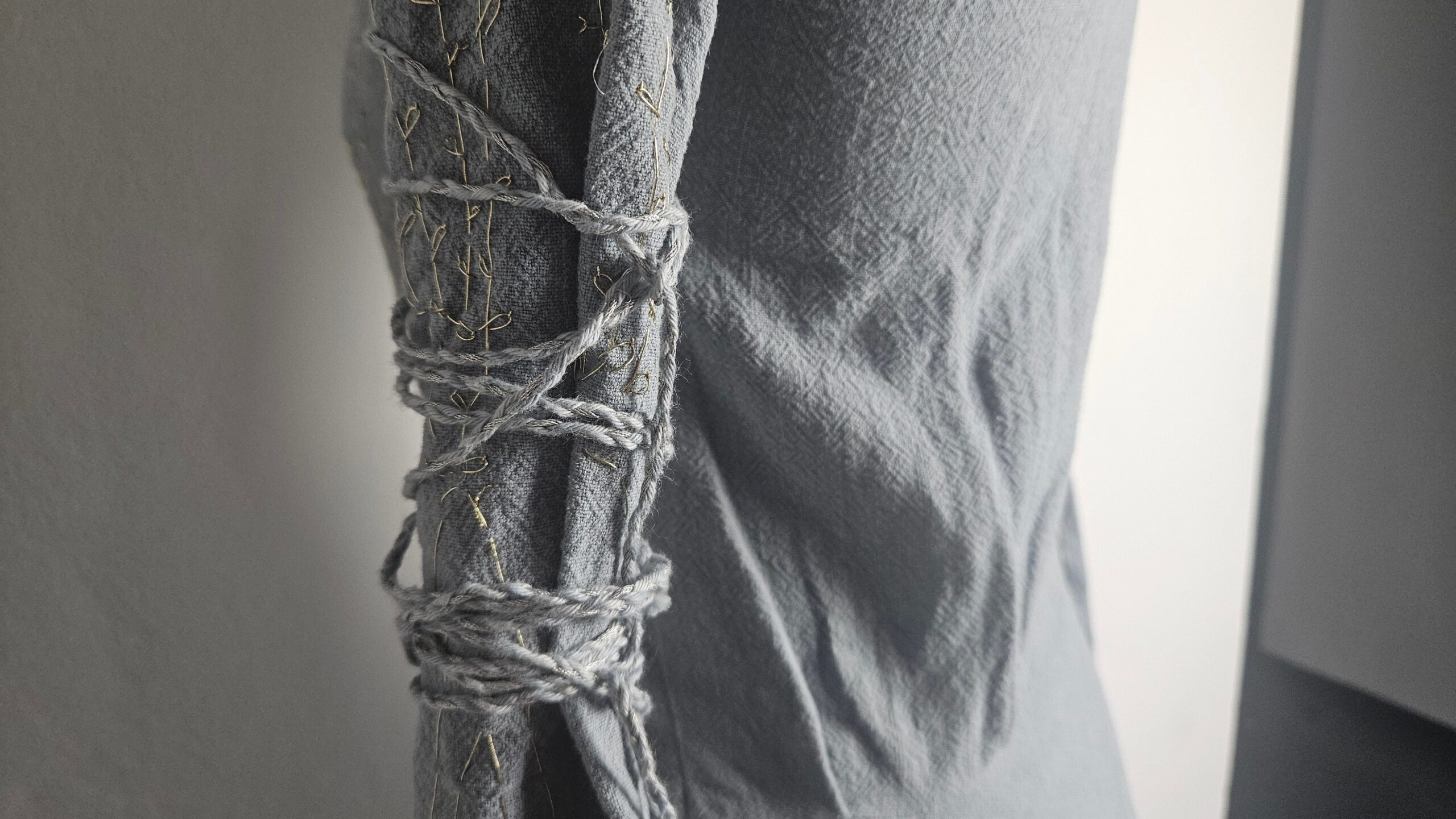 Arm cords wrapped around the sleeve of the dress