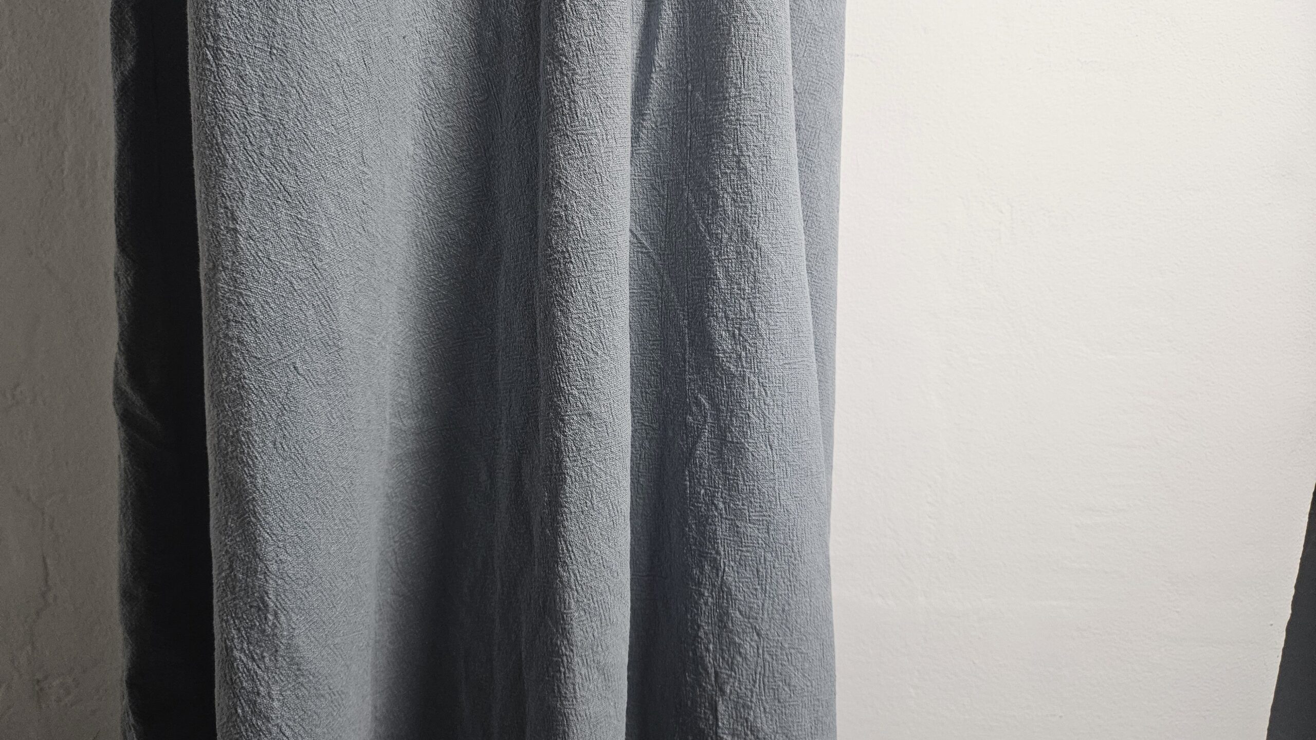 Blue linen fabric hanging to show how it drapes