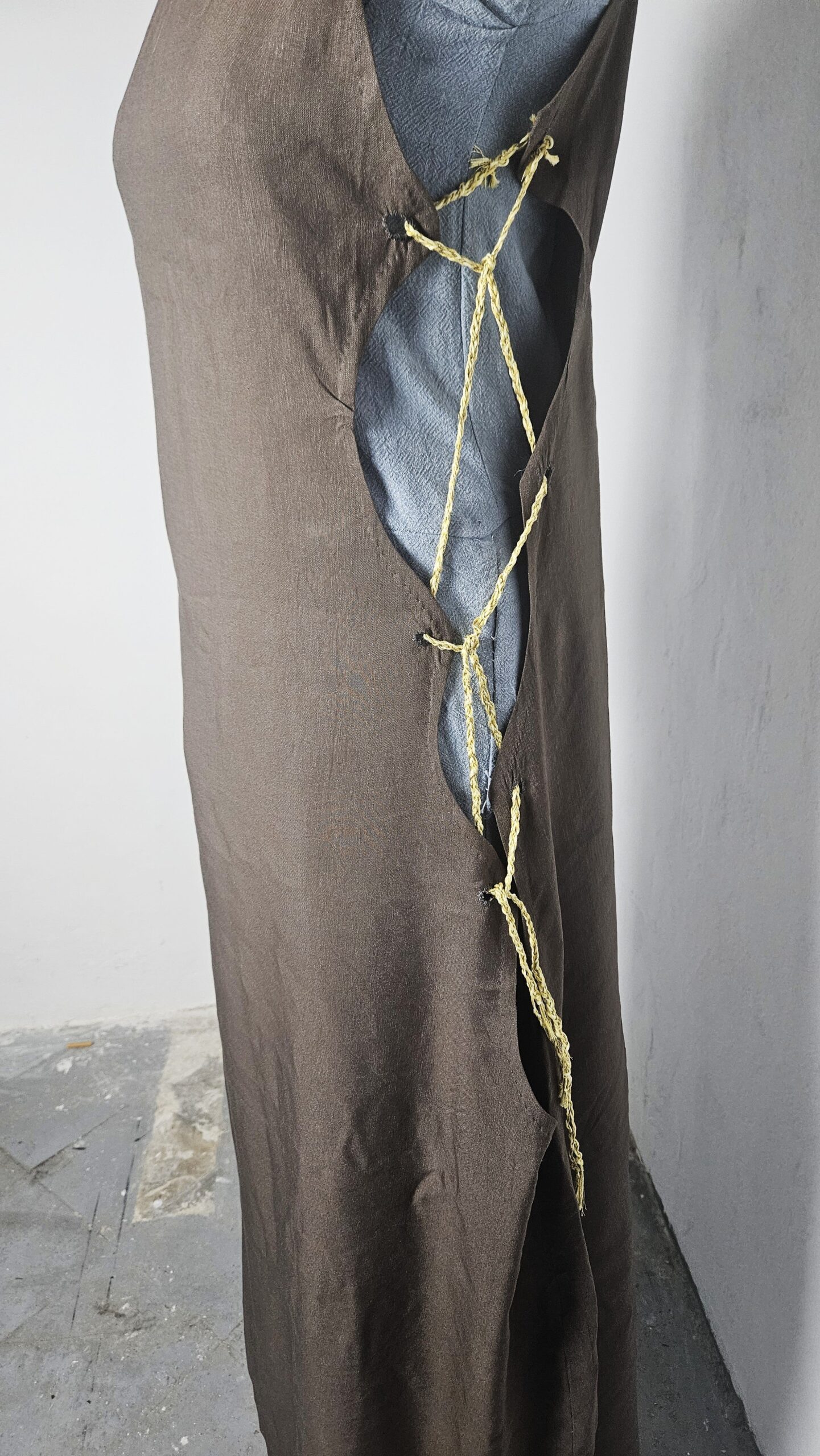 Arm cords laced around the sleeve of the blue dress