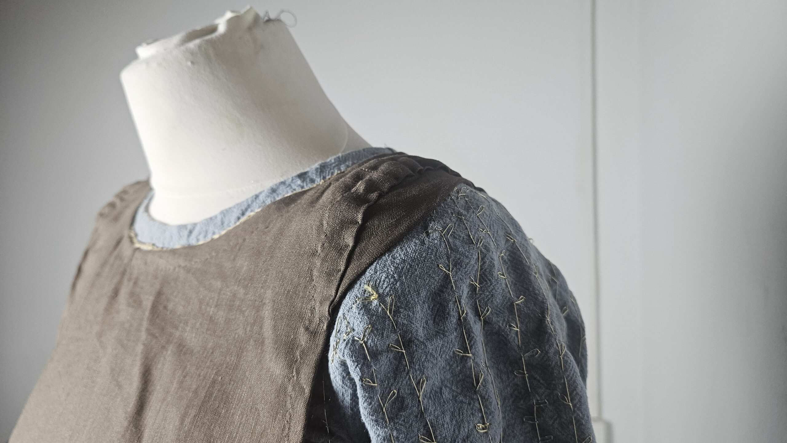 Brown overdress layered over the blue dress on the mannequin