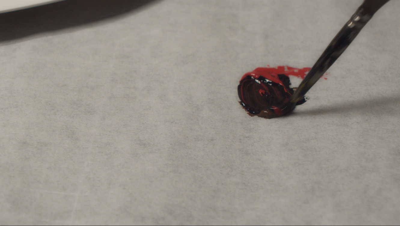 Mixing dark red acrylic paint for the sword's detail work