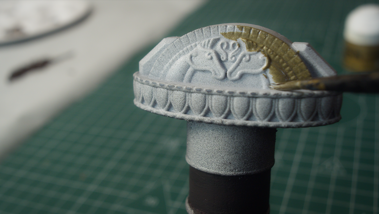 Gold paint applied to the horse-head relief on the pommel