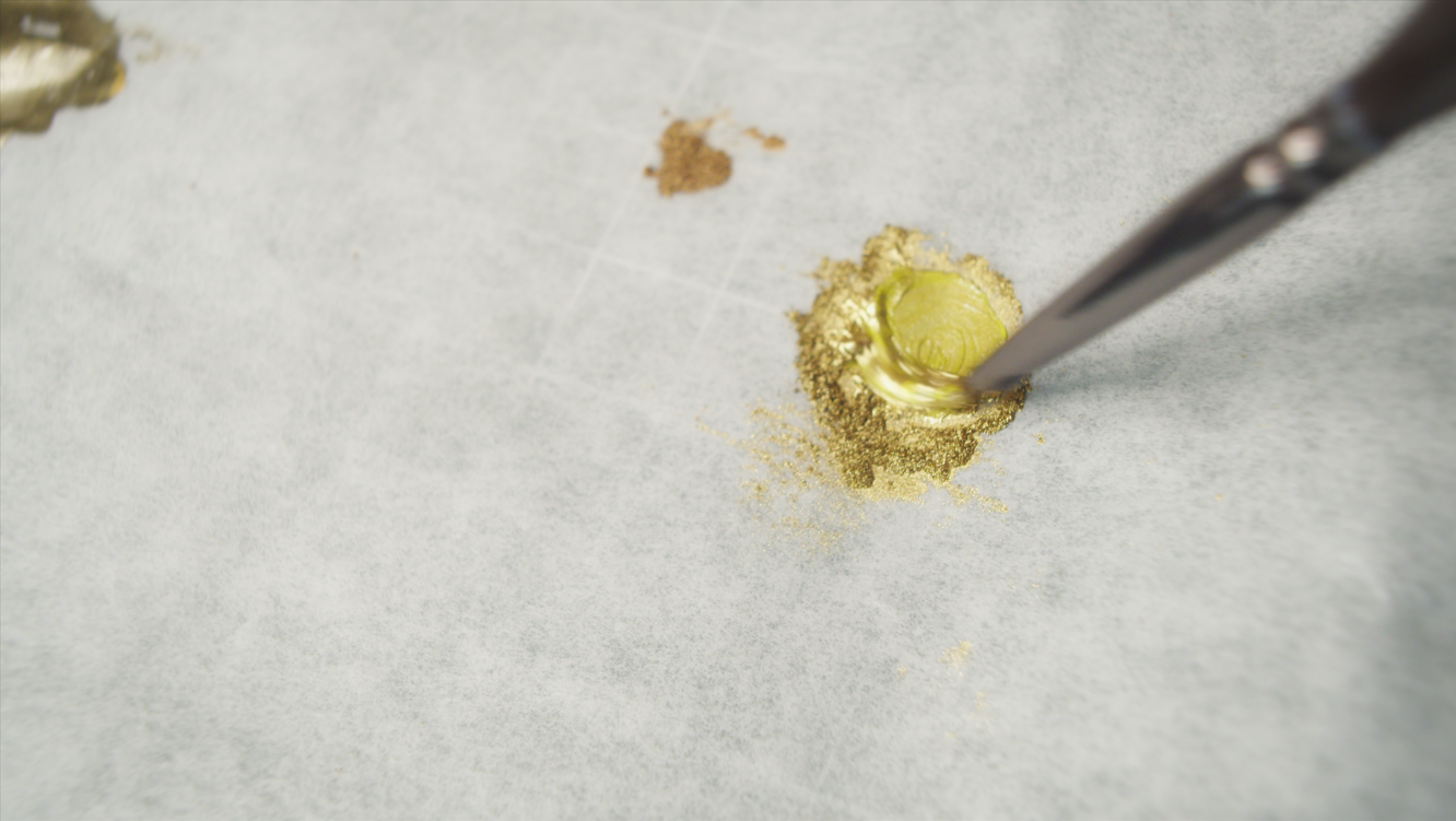 Mixing gold pigment powder for the sword's metallic details