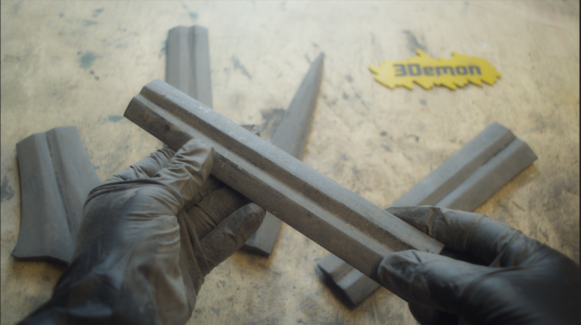 Sanding the 3D printed sword blade smooth with gloved hands
