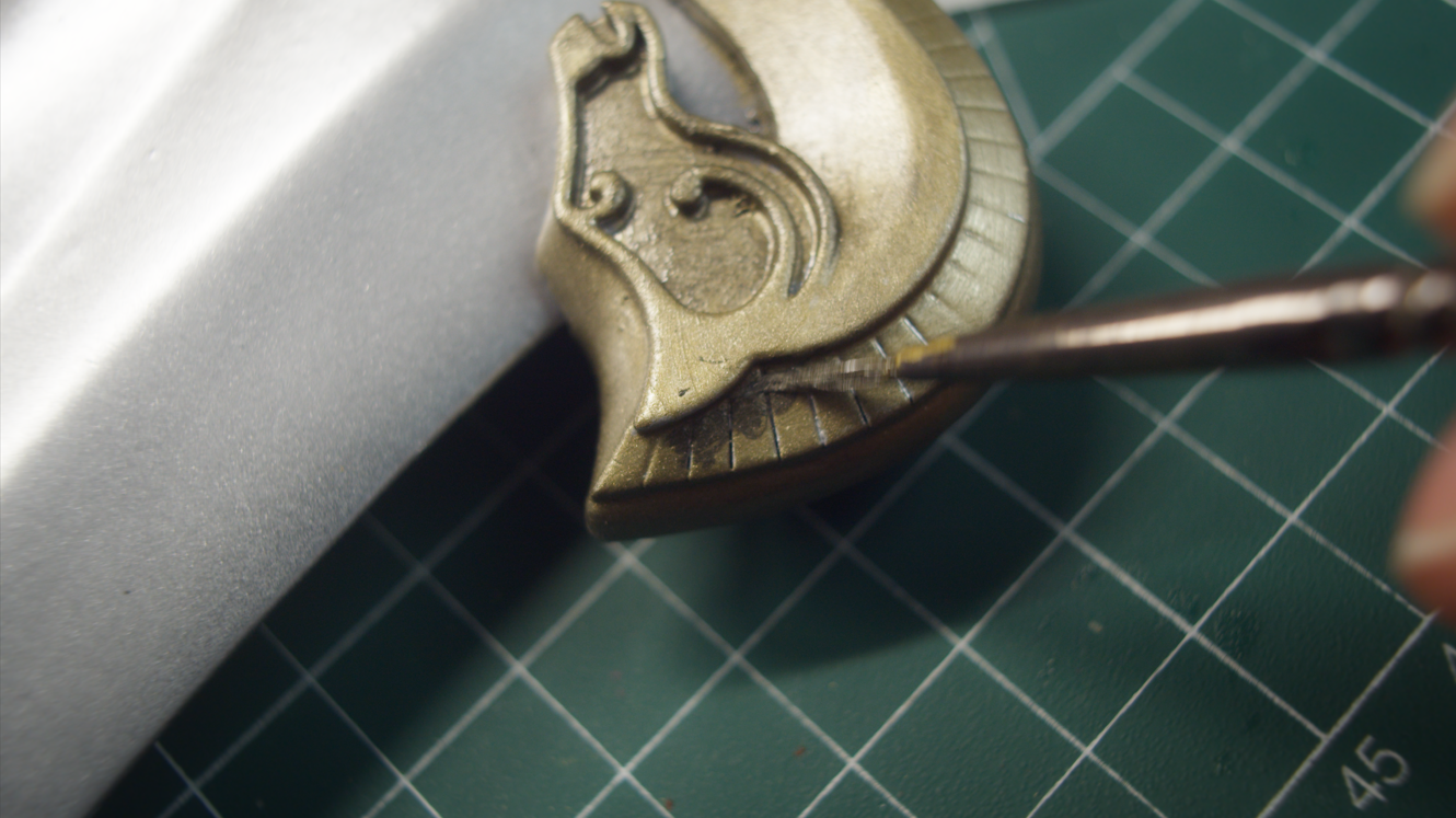 Adding shading to the gold crossguard with a fine brush