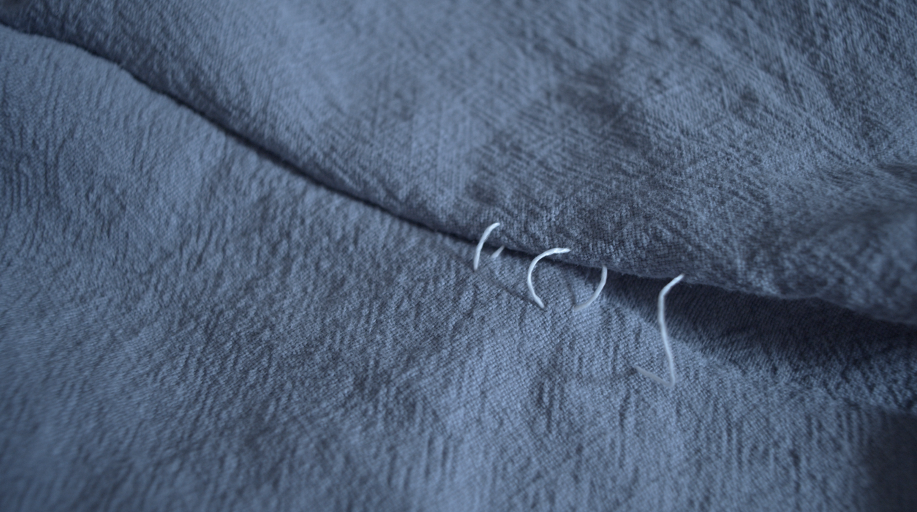 Pinning the seam of the blue dress before sewing